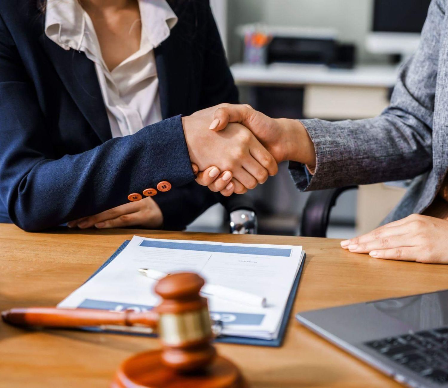 a couple of people shaking hands over a desk