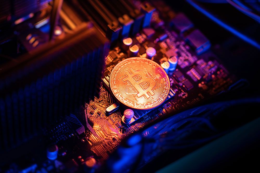 Bitcoin coin on a computer motherboard, representing cryptocurrency mining and blockchain technology.