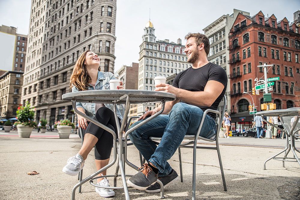 A happy couple enjoying coffee at an outdoor café near the Flatiron Building in California City.