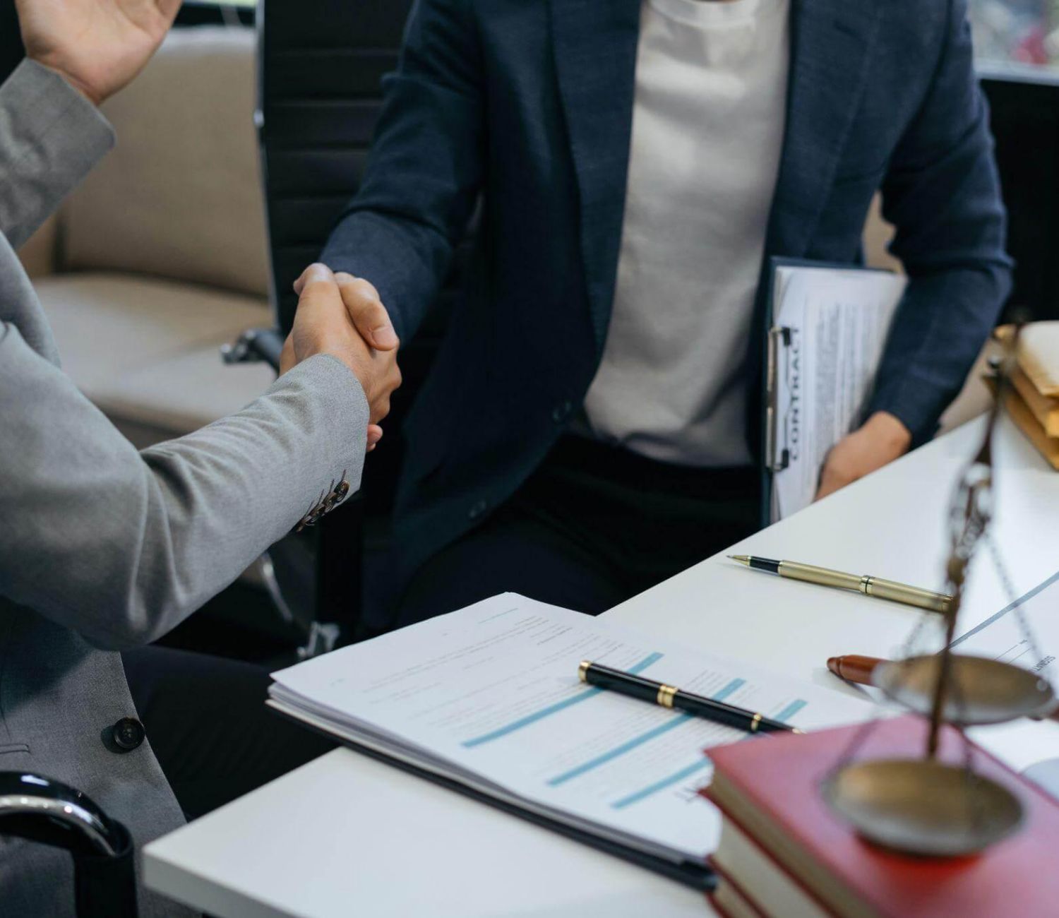 a couple of people shaking hands over a desk
