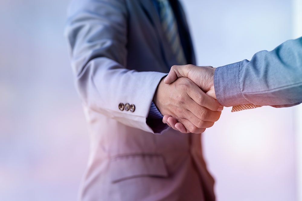 Businessmen in suits shaking hands, symbolizing partnership and successful professional agreement.