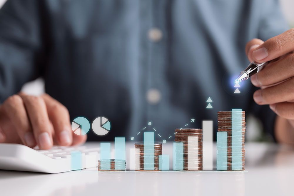 Person analyzing financial growth with calculator, money stacks, and charts, highlighting business investment insights.