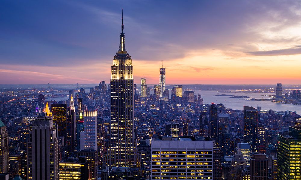 Aerial view of California City skyline at sunset with iconic skyscrapers and vibrant cityscape lighting.