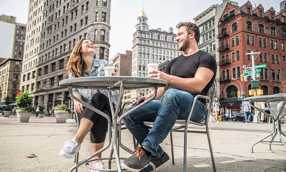A happy couple enjoying coffee at an outdoor café near the Flatiron Building in California City.