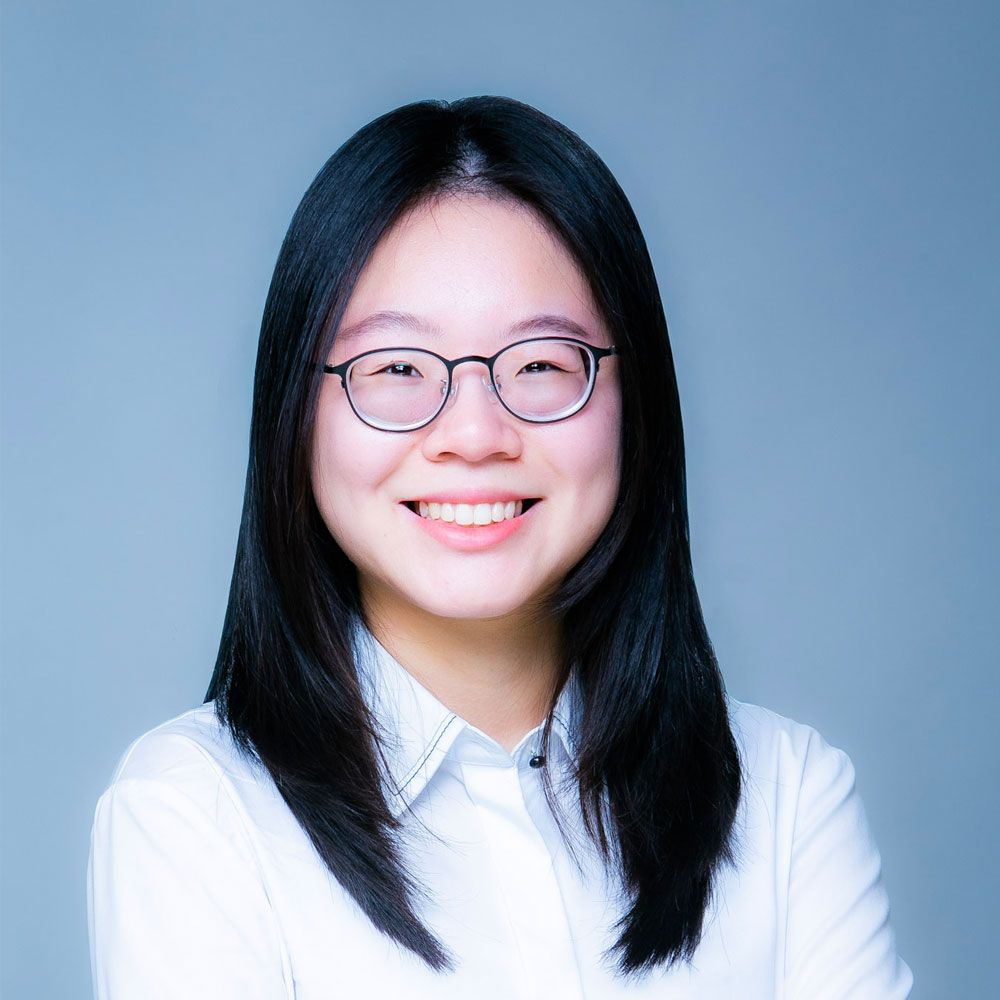 Weiwei with glasses and long black hair wearing a white shirt, set against a plain background.