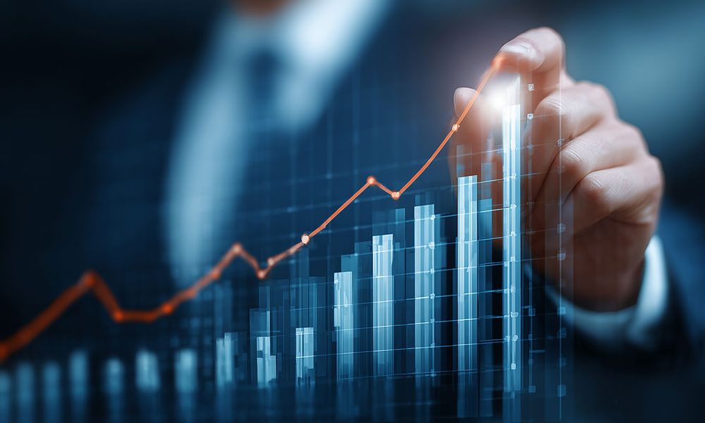 Businessman analyzing financial growth graph with rising bar chart.