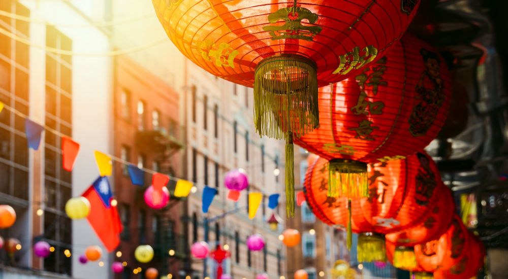 Red lanterns and colorful flags in a street festival, showcasing vibrant decorations and cultural celebration.