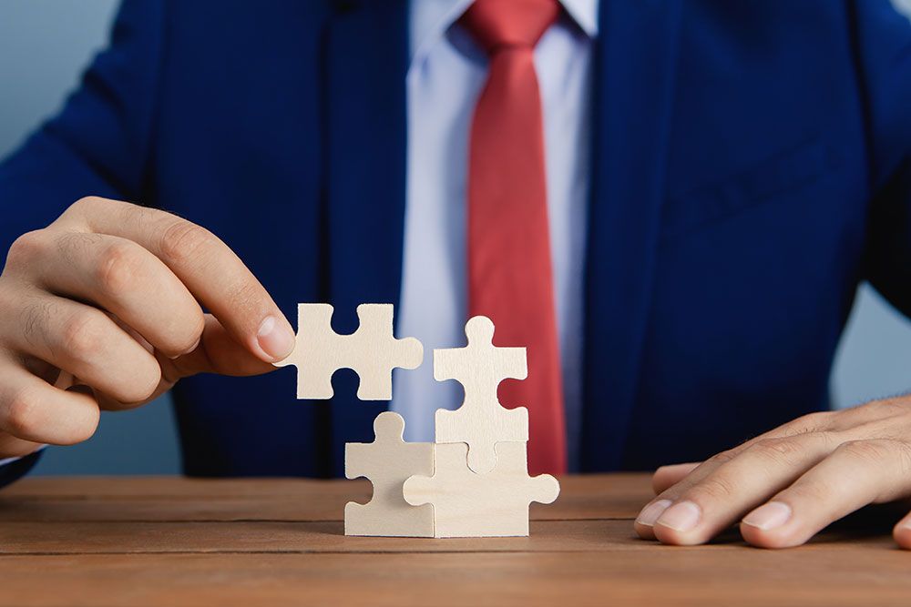 Businessman in suit solving puzzle, symbolizing strategy and problem-solving.