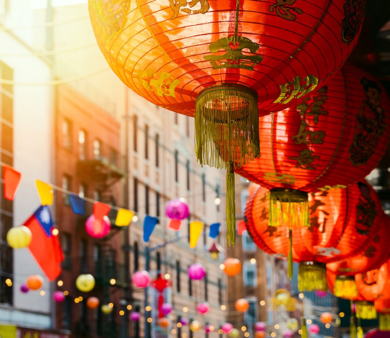 Red lanterns and colorful flags in a street festival, showcasing vibrant decorations and cultural celebration.