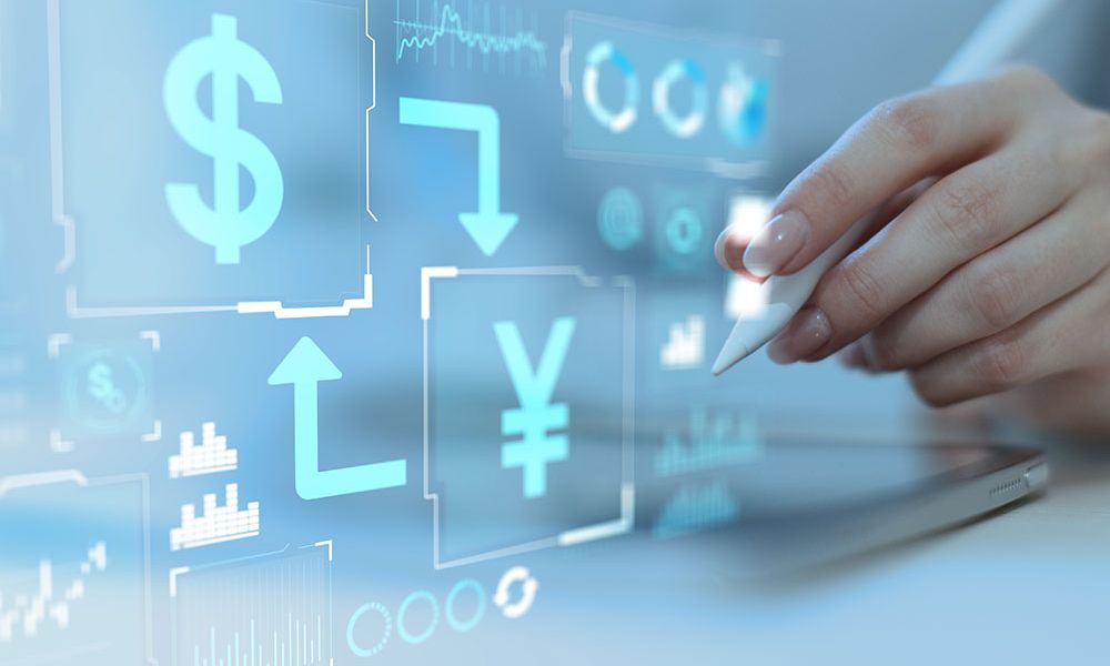 Touchscreen with currency symbols and graphs, hand holding stylus, digital financial interface concept.