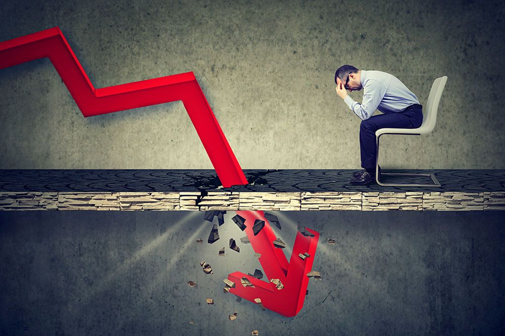 Businessman stressed by declining financial graph breaking the surface.