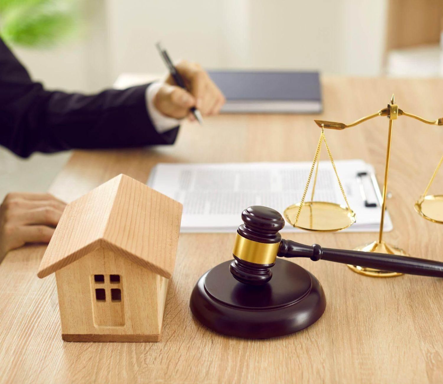 a judge's gavel and a model house on a desk