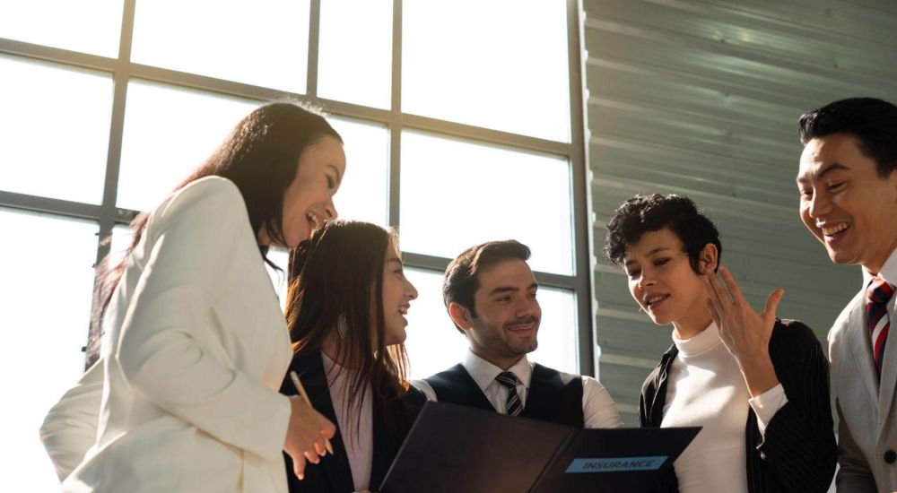 a group of business people standing around each other