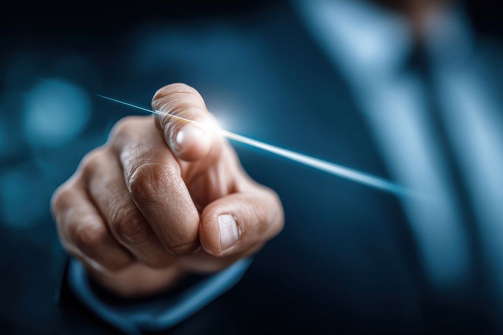 Finger touching digital interface with blue light, symbolizing technology and innovation in a futuristic business setting.