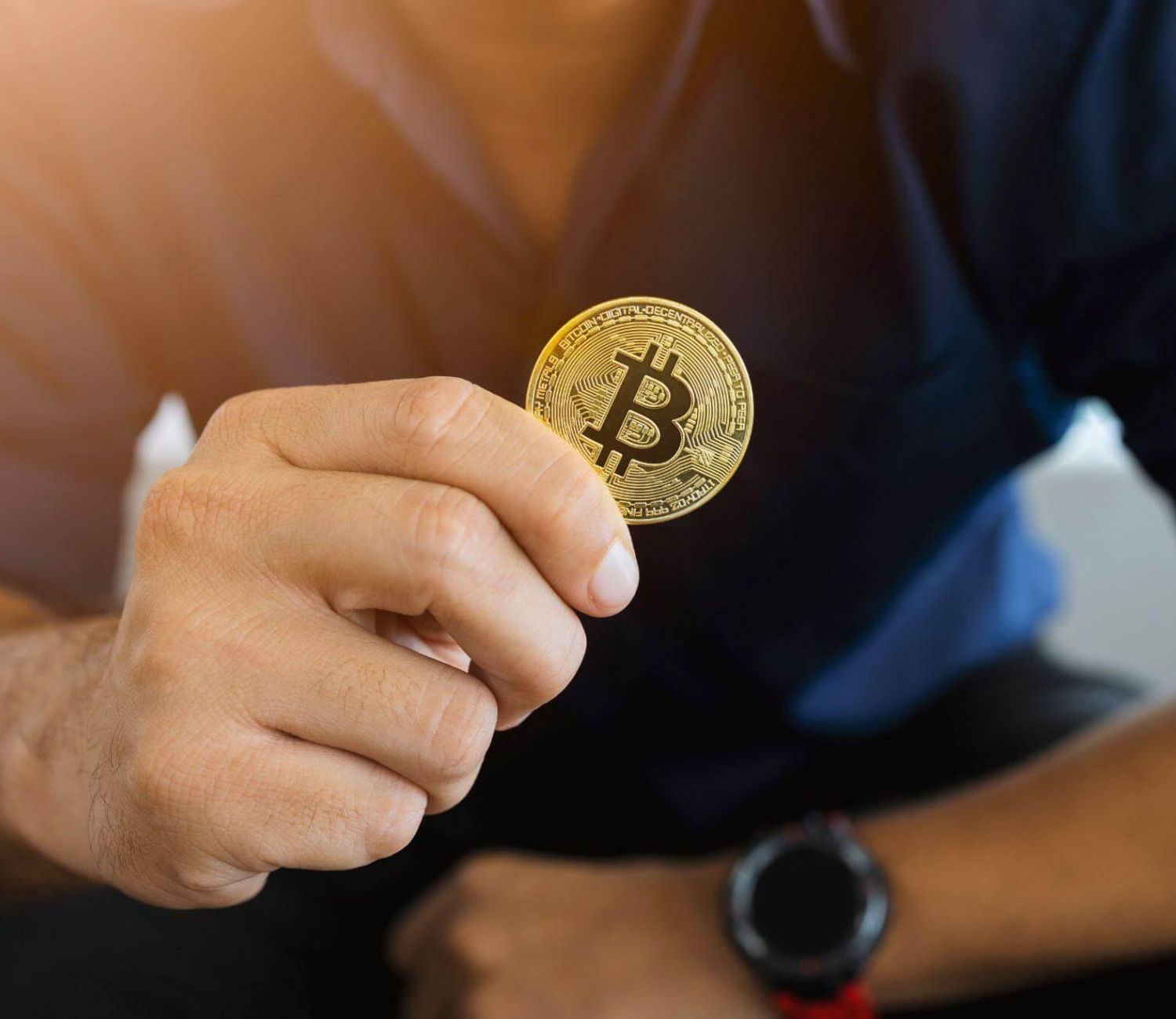 a man holding a bit coin in his hand