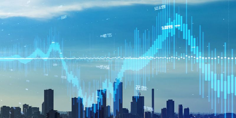City skyline with digital financial graph overlay, illustrating data trends and urban economic growth.