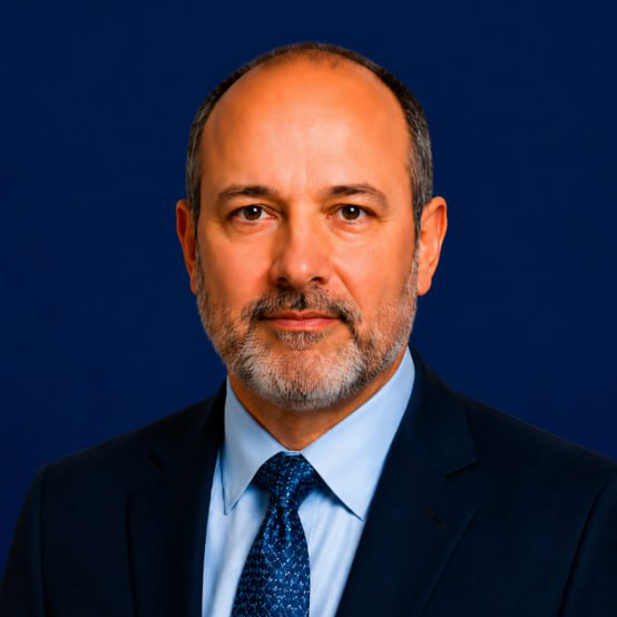 Brad Joel Caftel in a black blazer and white blouse against a blurred office background.