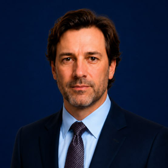 Professional man in suit and glasses with a blurred office background.