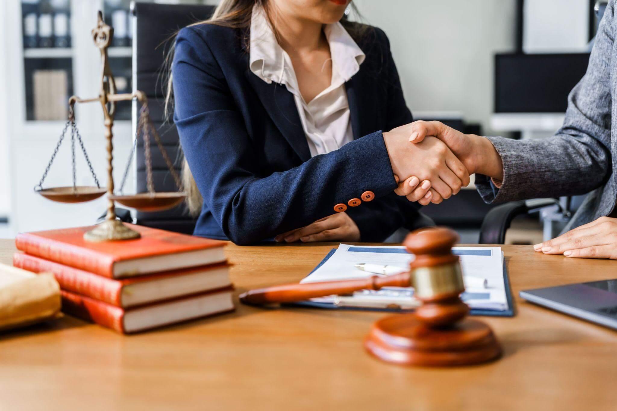 a couple of people shaking hands over a wooden table