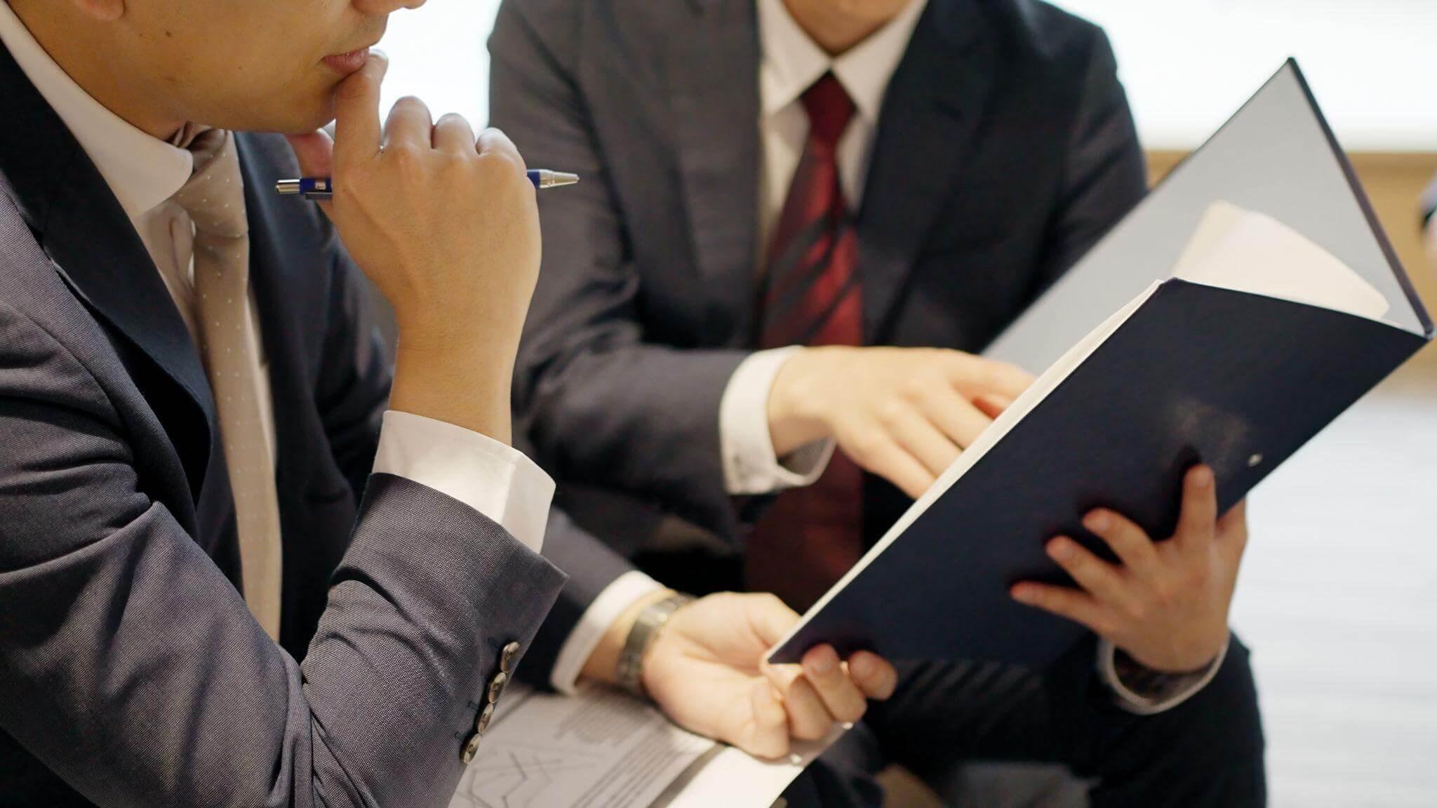 a man in a suit and tie holding a book